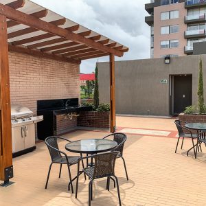 Terraza con mesas y zona BBQ del proyecto Ciudad Hayuelos Santiago de Tunja